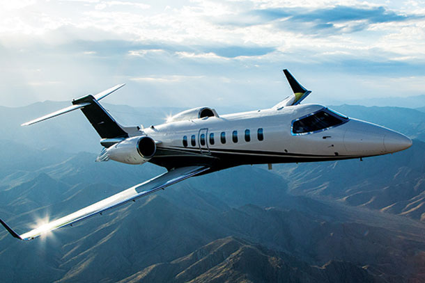 Flexjet - Jet flying over mountains.